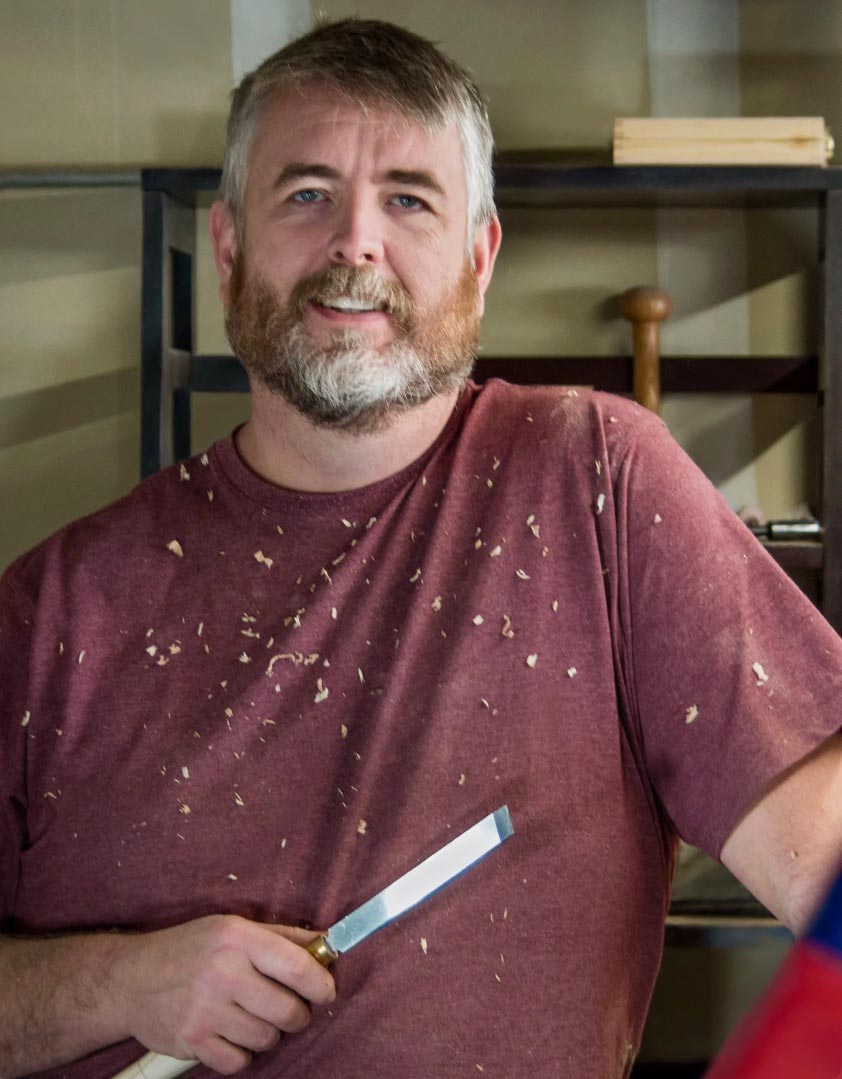 Brian Bretzinger in the woodshop holding a turning tool